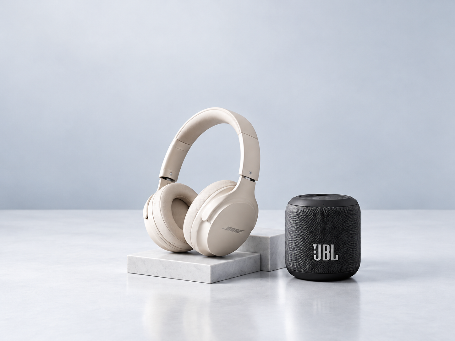 Bose headphones and a JBL speaker on marble blocks